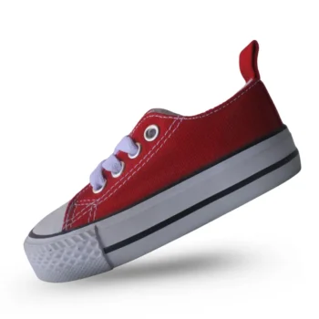 Zapato infantil rojo de lona con cordones blancos. Calzado casual para niños, ideal para jugar